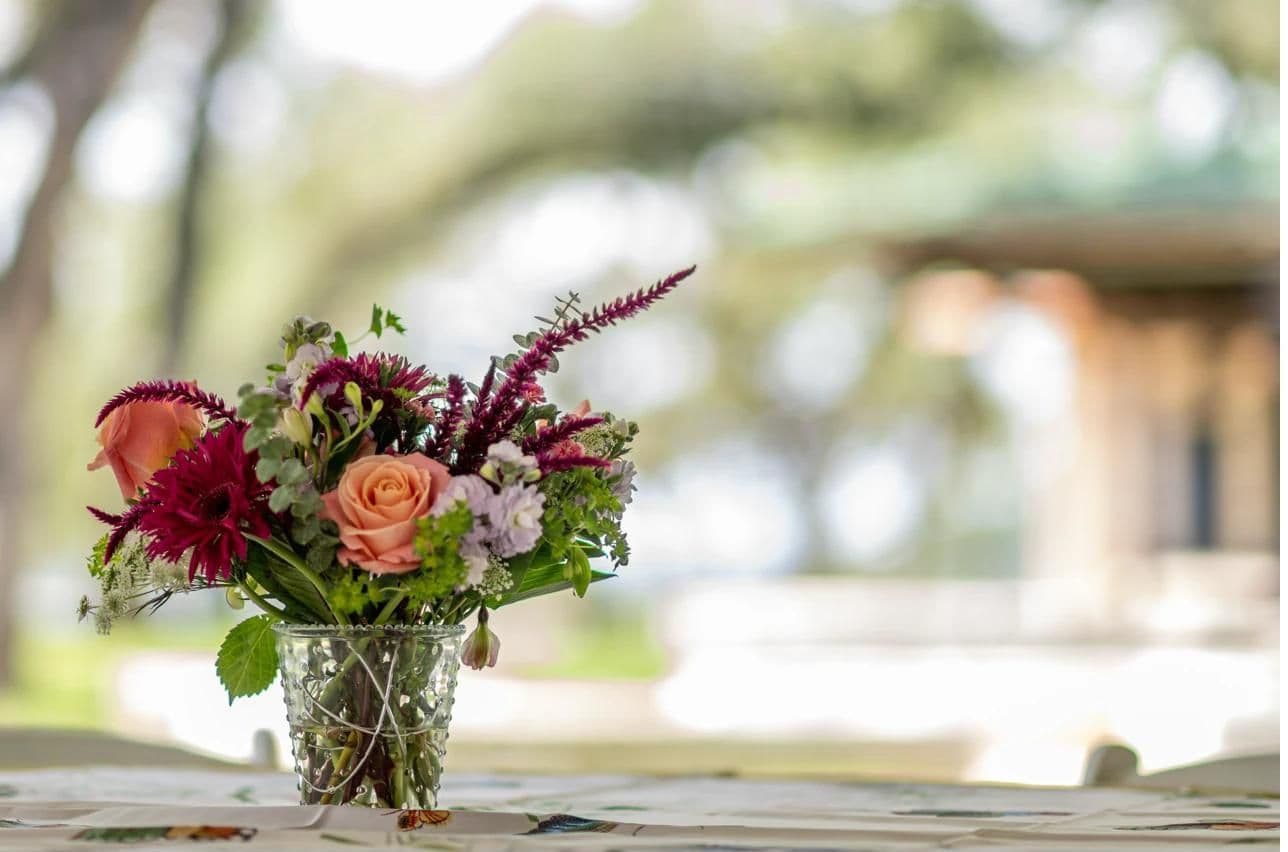 Wedding floral centerpiece with oak grove bokeh in the background